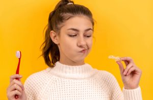 woman holding toothbrush, consider dental care shared by her healthshare