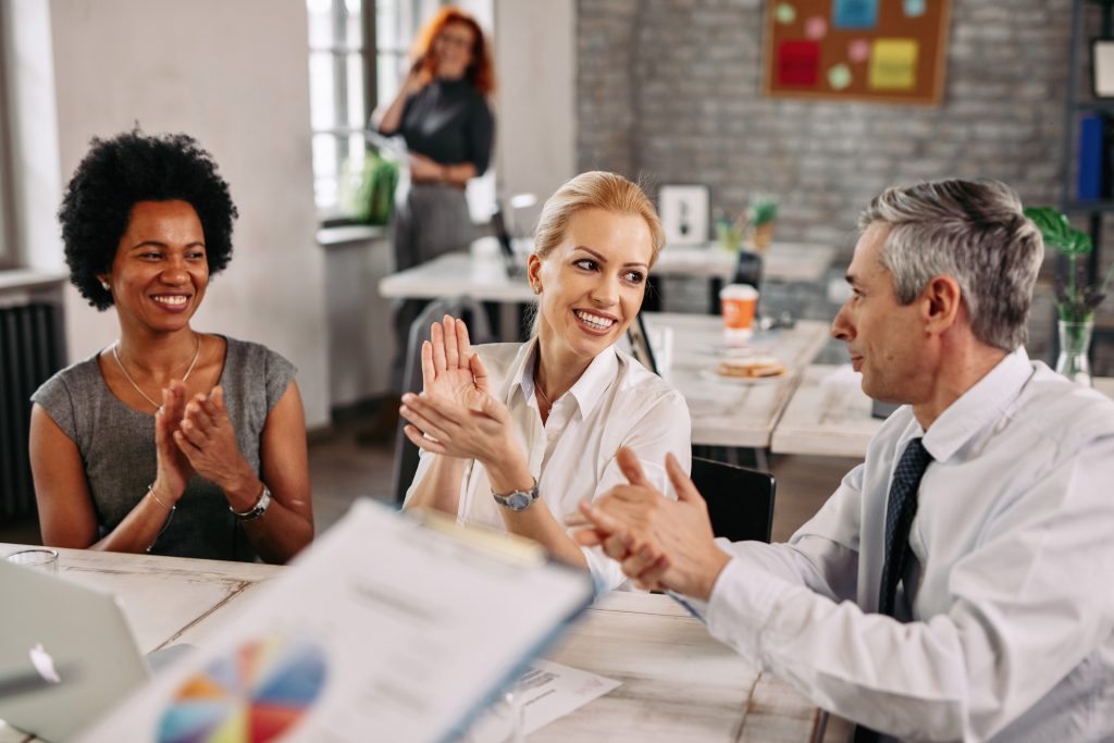 a group of happy coworkers clapping