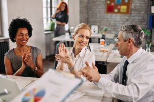 a group of happy coworkers clapping
