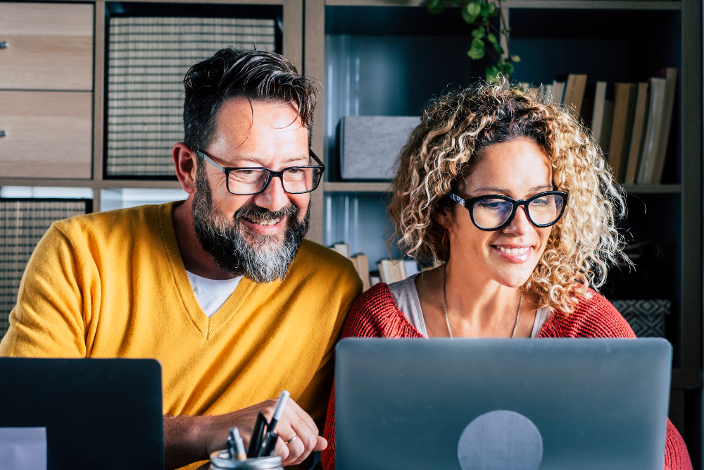 man and woman looking at computer screen