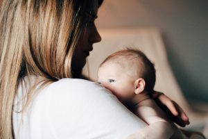 Mother lovingly holding her newborn baby, suggesting family health considerations in HealthShares