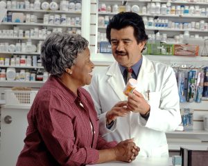 Pharmacist assisting an elderly woman in finding the right medication.