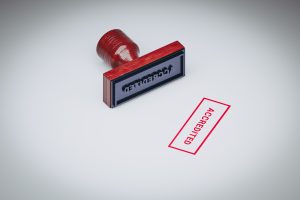 A red rubber stamp with the word "Accredited" imprinted on white paper.