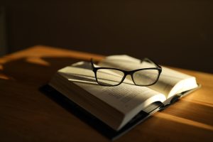 A pair of glasses rests atop an open book