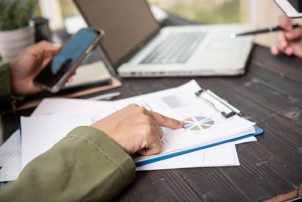 A woman's hands pointing at a paper report.