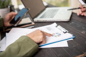 A woman's hands pointing at a paper report.