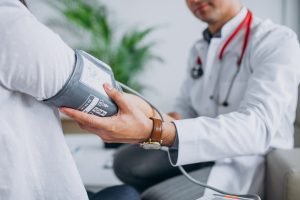 a young physician checks a patient's blood pressure with a cuff.